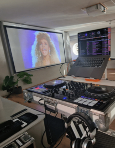 DJ Pult und Leinwand mit Musikvideo